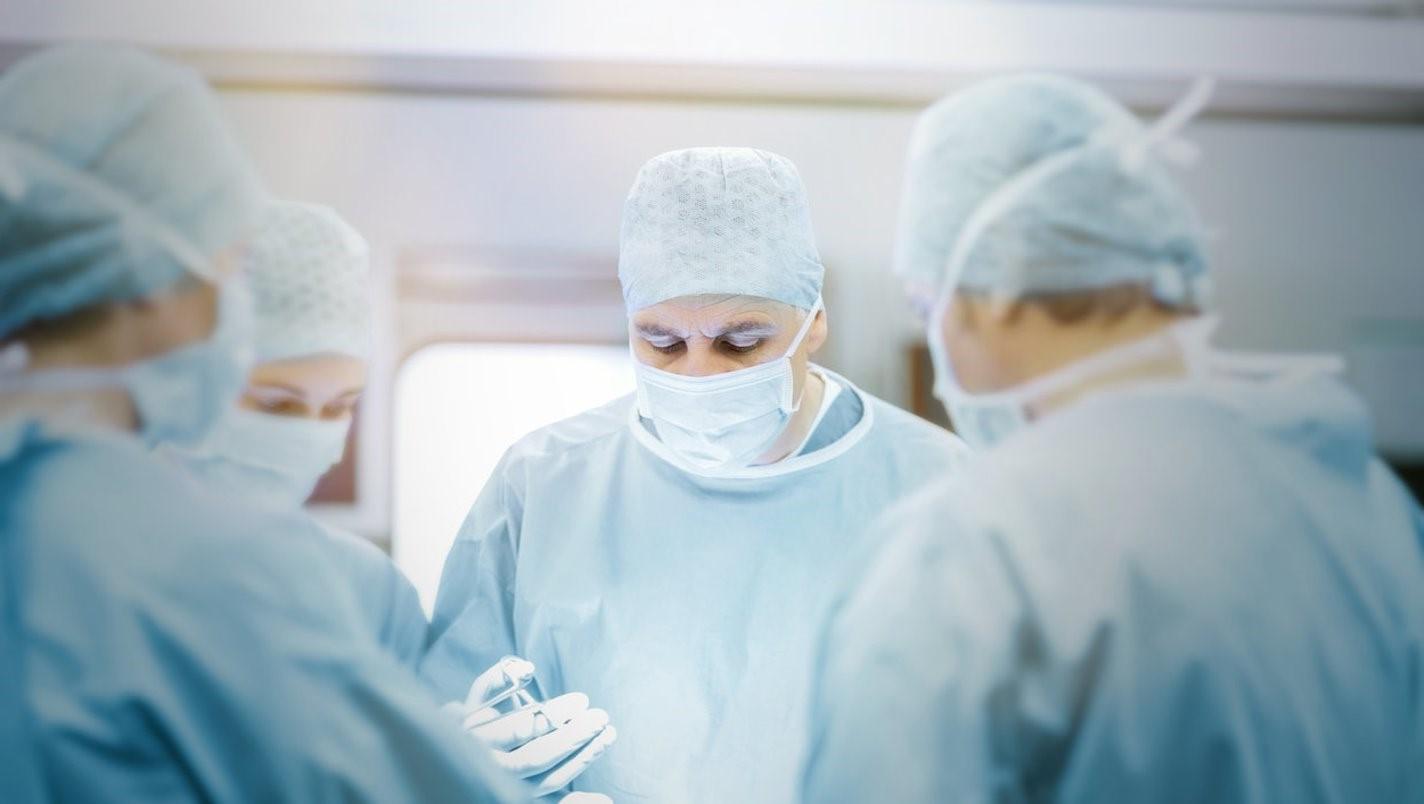 Doctors in gowns and face masks performing surgery